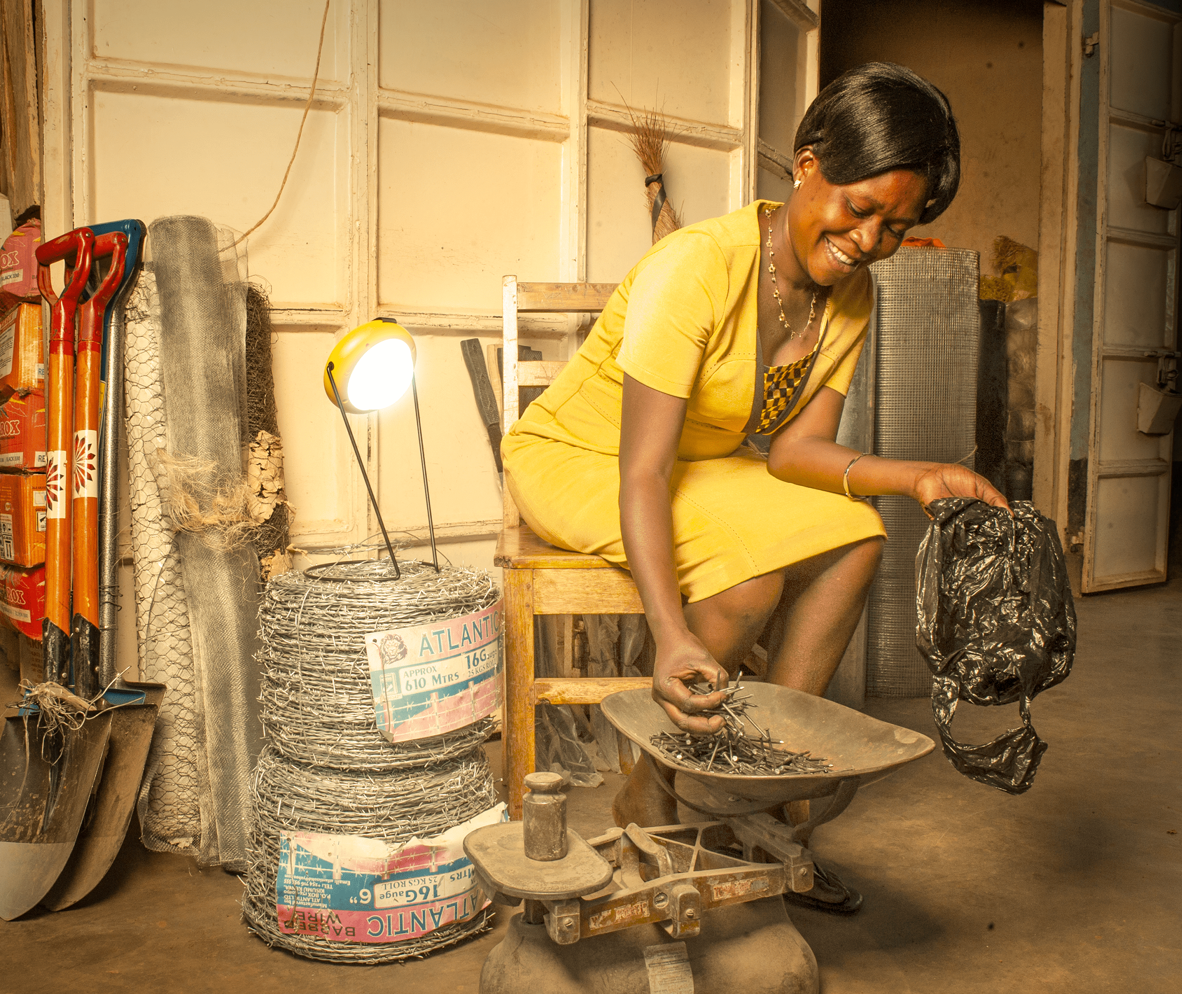 A woman uses the Sun King Pro 200 portable solar powered lantern to light up her space as she works.